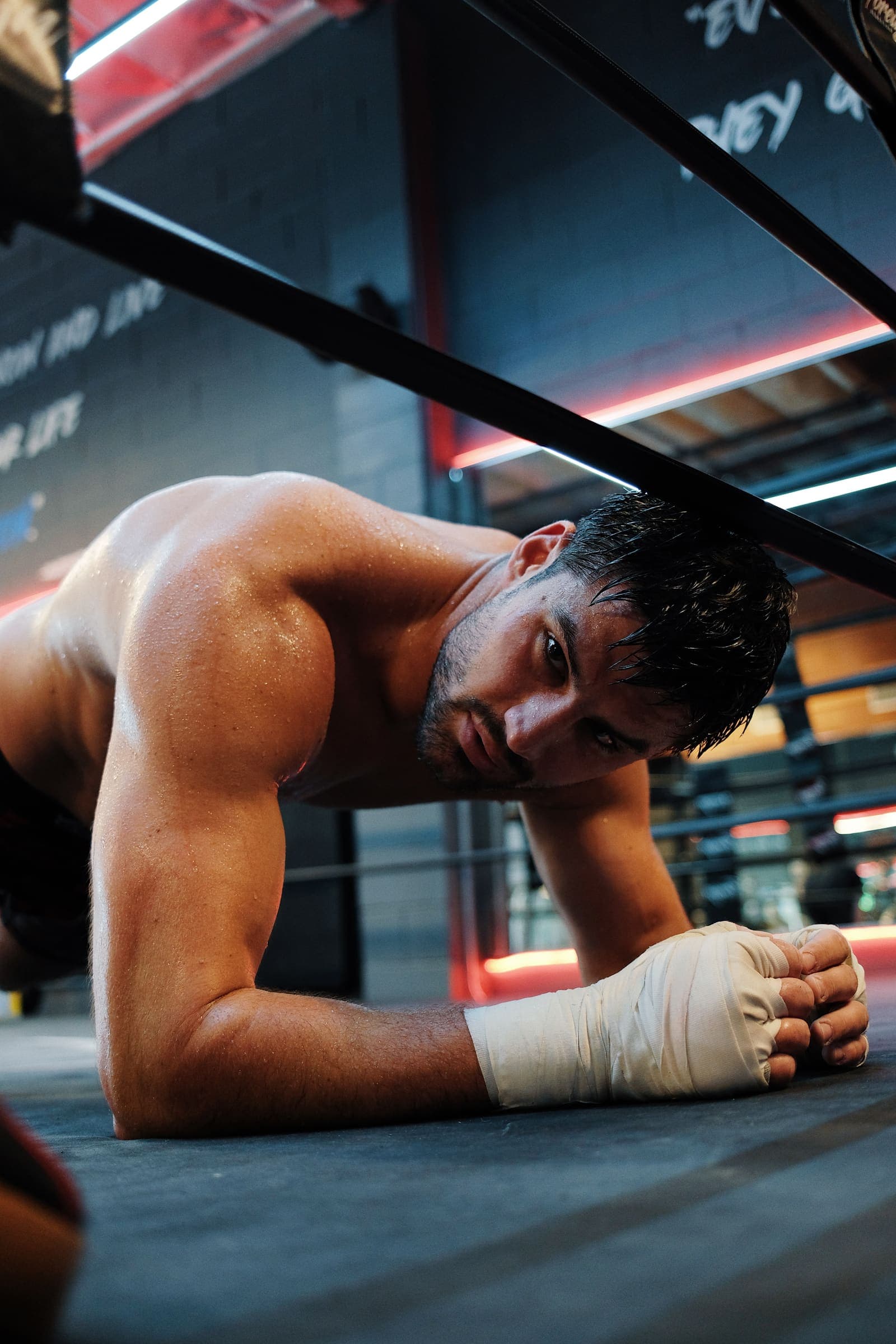 Andrii Novytskyi holding a plank on the ring floor, hands wrapped, eyes up